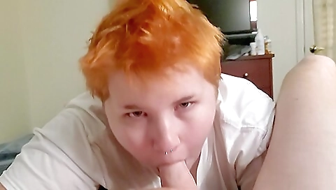 Red head with a tattooed face is taking off clothes